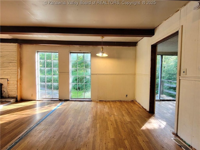 807 Honeysuckle Rd, Elkview, WV 25071 - unfurnished dining area with wood finished floors, beam ceiling, healthy amount of natural light, and a decorative wall