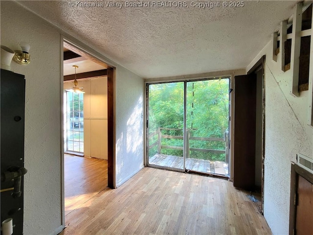 807 Honeysuckle Rd, Elkview, WV 25071 - unfurnished room featuring a textured wall, wood finished floors, and a textured ceiling