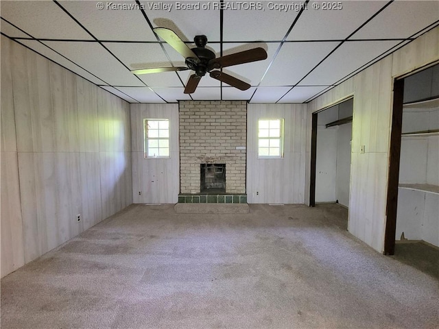807 Honeysuckle Rd, Elkview, WV 25071 - unfurnished living room with carpet, a paneled ceiling, ceiling fan, a brick fireplace, and wood walls