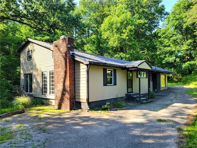 807 Honeysuckle Rd, Elkview, WV 25071 - view of front of house with a chimney, driveway, and a metal roof