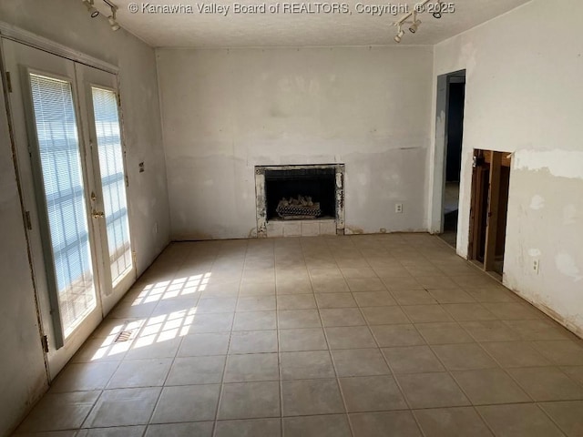 134 Ferguson Ct, Huntington, WV 25701 - unfurnished living room featuring french doors, a fireplace, tile patterned flooring, and track lighting