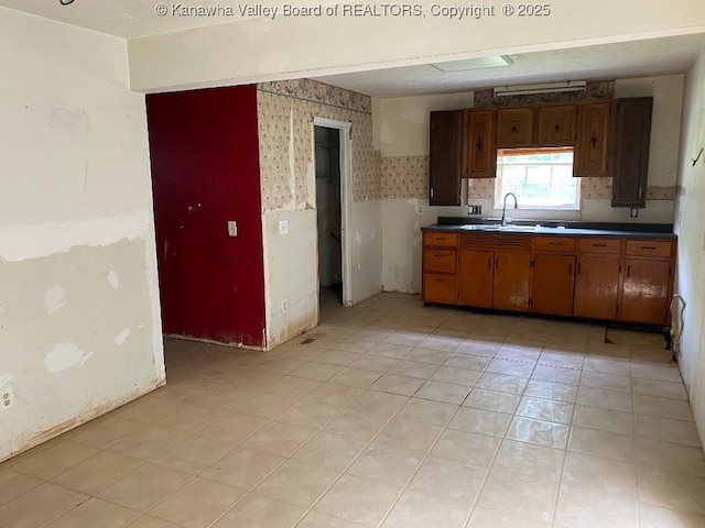 134 Ferguson Ct, Huntington, WV 25701 - kitchen with wallpapered walls, wainscoting, and brown cabinetry