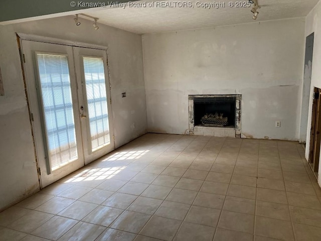 134 Ferguson Ct, Huntington, WV 25701 - unfurnished living room with rail lighting, french doors, a fireplace, and light tile patterned floors