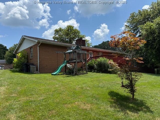 2234 Circle Dr, Milton, WV 25541 - rear view of property featuring brick siding, a yard, and a playground