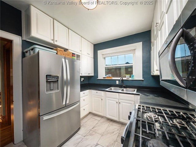 2961 Staunton Rd, Huntington, WV 25702 - kitchen featuring appliances with stainless steel finishes, white cabinetry, light marble finish flooring, and dark countertops