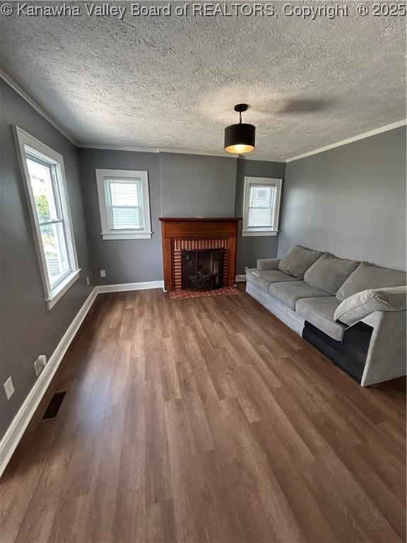 2010 Preston St, Charleston, WV 25302 - living area featuring wood finished floors, ornamental molding, a textured ceiling, and a fireplace