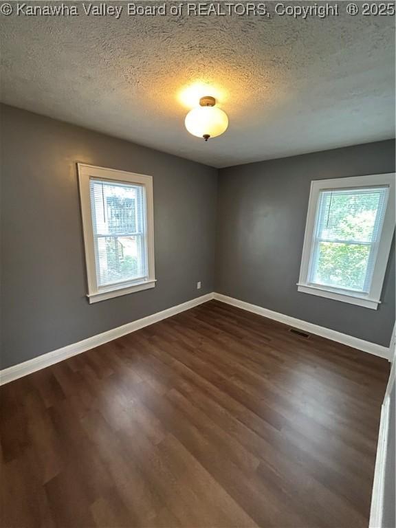 2010 Preston St, Charleston, WV 25302 - empty room with healthy amount of natural light, dark wood-style flooring, and a textured ceiling