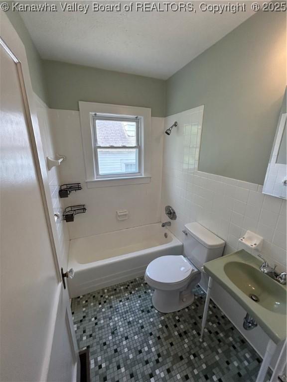 2010 Preston St, Charleston, WV 25302 - bathroom with tile walls, shower / tub combination, tile patterned floors, and a wainscoted wall