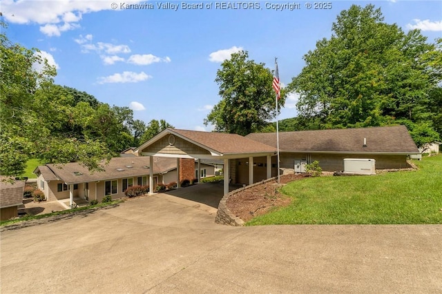 33 Shawnee Oaks Dr, Huntington, WV 25705 - ranch-style home with driveway, a front lawn, and a carport