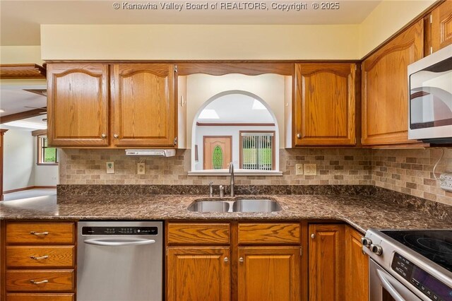 33 Shawnee Oaks Dr, Huntington, WV 25705 - kitchen featuring appliances with stainless steel finishes, backsplash, brown cabinetry, and dark stone counters