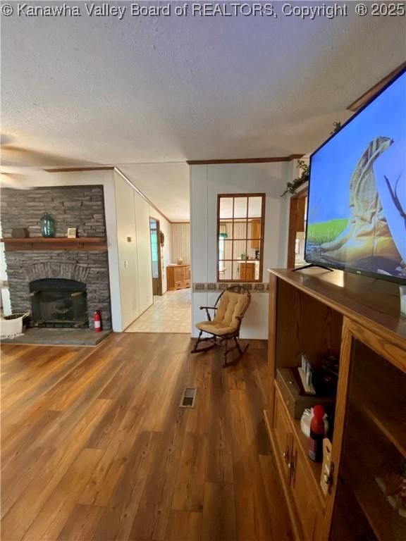 2399 Spicewood Rd, Kenna, WV 25248 - living room with a textured ceiling, wood finished floors, and a stone fireplace