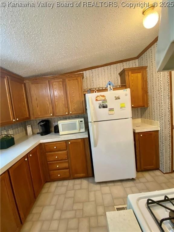 2399 Spicewood Rd, Kenna, WV 25248 - kitchen featuring white appliances, wallpapered walls, brown cabinetry, light countertops, and brick patterned flooring