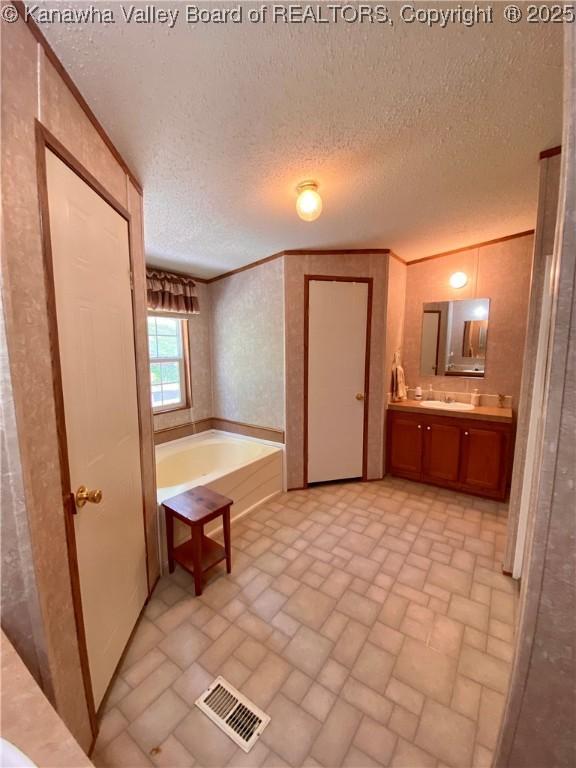 2399 Spicewood Rd, Kenna, WV 25248 - full bathroom with vanity, brick patterned floors, a garden tub, and a textured ceiling