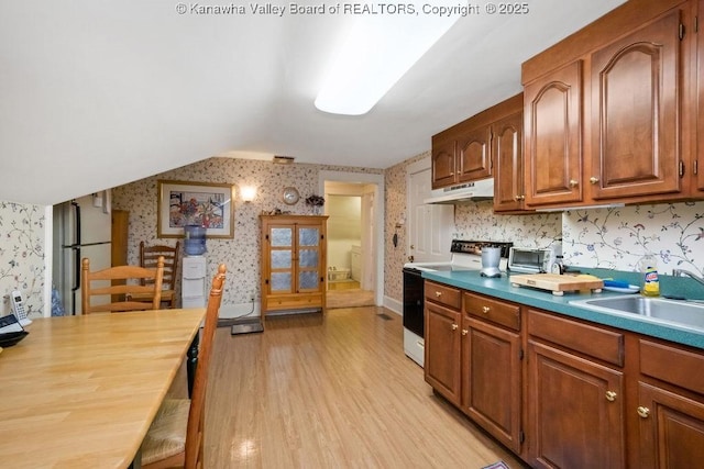 1598 Kanawha Blvd E, Charleston, WV 25311 - kitchen with wallpapered walls, white range with electric cooktop, light wood-style floors, freestanding refrigerator, and brown cabinetry