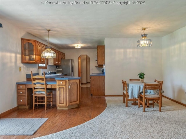 3710 Cambridge Cir, Hurricane, WV 25526 - kitchen with stainless steel fridge, brown cabinets, dark countertops, a peninsula, and glass insert cabinets