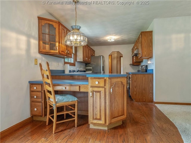 3710 Cambridge Cir, Hurricane, WV 25526 - kitchen with stainless steel appliances, brown cabinetry, a peninsula, arched walkways, and glass insert cabinets