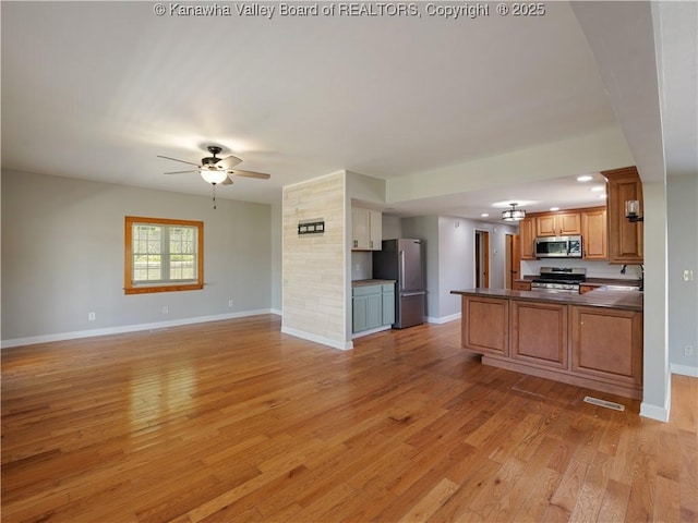 9012 Florida Ave, Marmet, WV 25315 - kitchen with stainless steel appliances, open floor plan, ceiling fan, dark countertops, and a peninsula