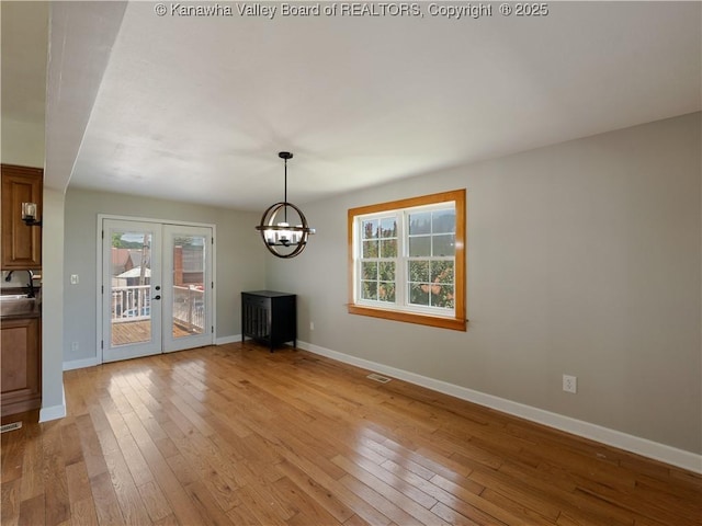 9012 Florida Ave, Marmet, WV 25315 - unfurnished dining area with healthy amount of natural light, light wood finished floors, a chandelier, and french doors