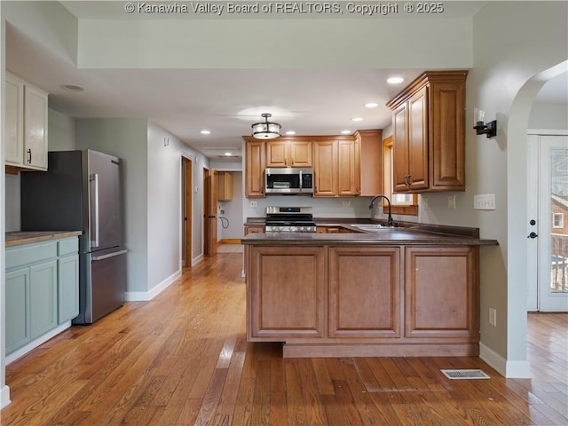 9012 Florida Ave, Marmet, WV 25315 - kitchen featuring stainless steel appliances, light wood-style floors, a peninsula, dark countertops, and recessed lighting