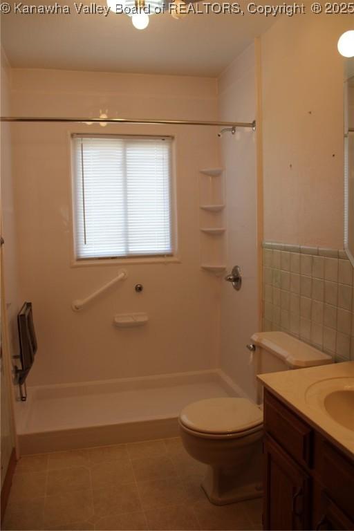 401 Green Acres Dr, Hurricane, WV 25526 - bathroom with vanity, a shower, tile walls, and wainscoting