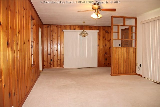 401 Green Acres Dr, Hurricane, WV 25526 - carpeted empty room featuring a ceiling fan, wooden walls, and arched walkways