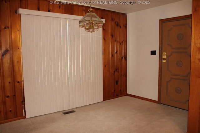 401 Green Acres Dr, Hurricane, WV 25526 - unfurnished dining area featuring carpet flooring, a chandelier, and wooden walls