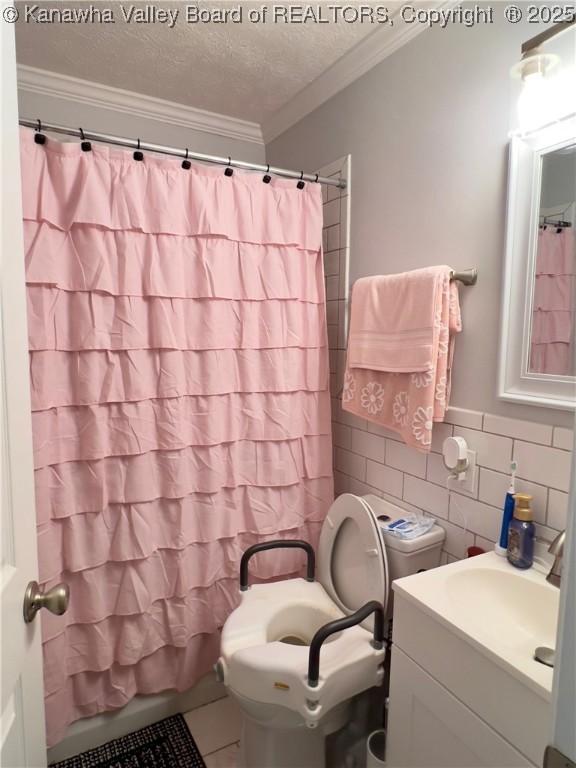 602 43rd St SE, Charleston, WV 25304 - full bathroom with vanity, crown molding, tile walls, and a textured ceiling
