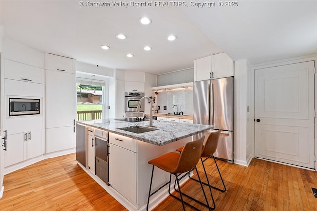 815 Chappell Rd, Charleston, WV 25304 - kitchen with stainless steel appliances, recessed lighting, a breakfast bar, light wood-type flooring, and white cabinetry