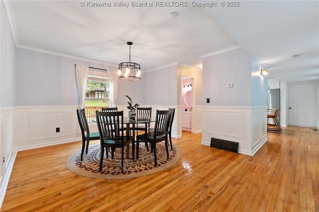 815 Chappell Rd, Charleston, WV 25304 - dining space featuring light wood-type flooring, a wainscoted wall, a chandelier, and crown molding