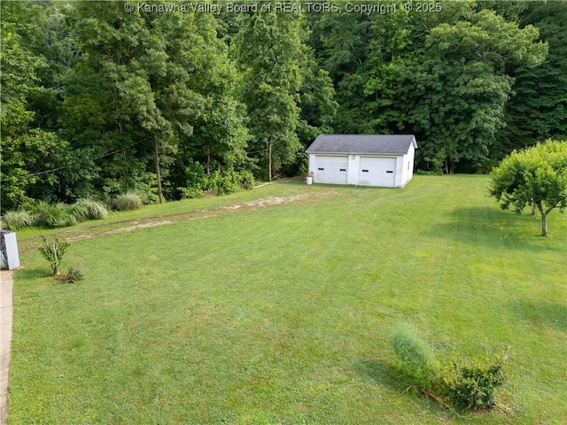 5490 Fisher Bowen Branch Rd, Wayne, WV 25570 - view of grassy yard featuring an outdoor structure, a garage, driveway, and a wooded view