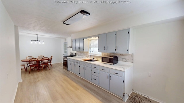 5490 Fisher Bowen Branch Rd, Wayne, WV 25570 - kitchen featuring appliances with stainless steel finishes, backsplash, light wood finished floors, light countertops, and a chandelier