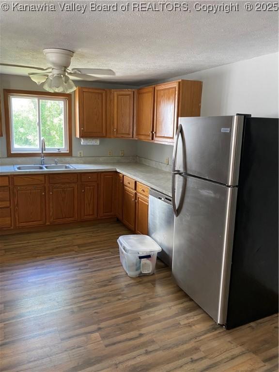 42 Pine Cone Rd, Elkview, WV 25071 - kitchen with stainless steel appliances, wood finished floors, brown cabinetry, and a textured ceiling