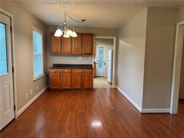 913 Charleston Rd, Point Pleasant, WV 25550 - kitchen with freestanding refrigerator, brown cabinets, a chandelier, and dark wood finished floors