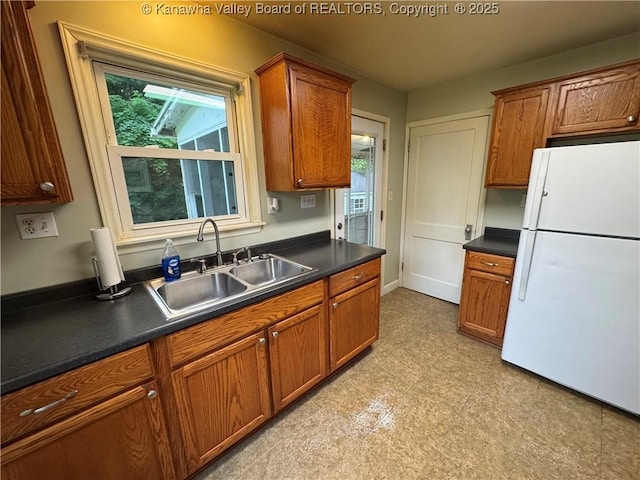 913 Charleston Rd, Point Pleasant, WV 25550 - kitchen with freestanding refrigerator, dark countertops, and brown cabinetry