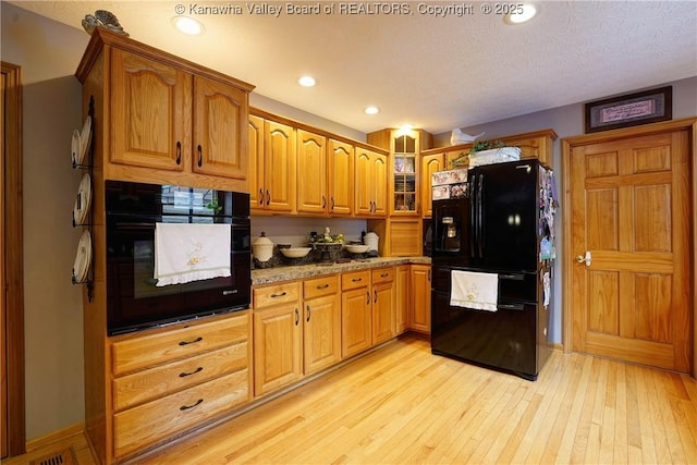 8 Anchors Way, Winfield, WV 25213 - kitchen featuring black appliances, light wood finished floors, glass insert cabinets, brown cabinets, and recessed lighting