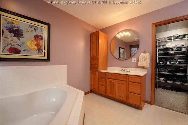 8 Anchors Way, Winfield, WV 25213 - bathroom featuring vanity, a garden tub, a spacious closet, and tile patterned floors