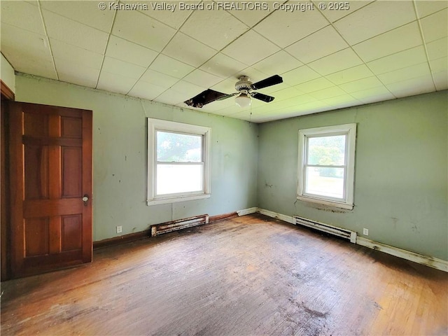 200 Boone St, Saint Albans, WV 25177 - empty room with healthy amount of natural light, wood finished floors, a baseboard radiator, a ceiling fan, and a paneled ceiling