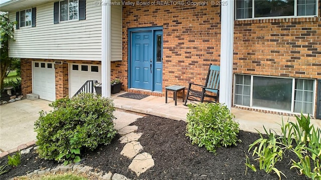 5301 Balsam Cir, Charleston, WV 25313 - doorway to property with brick siding, an attached garage, and concrete driveway