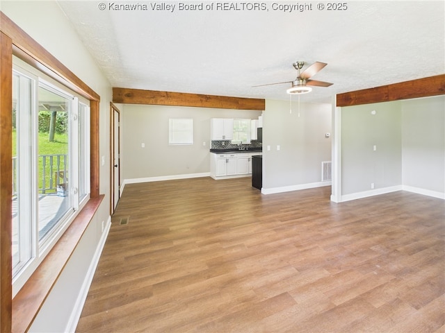 61 Sol Ln, Charleston, WV 25312 - unfurnished living room with a ceiling fan, a textured ceiling, light wood-type flooring, and beamed ceiling