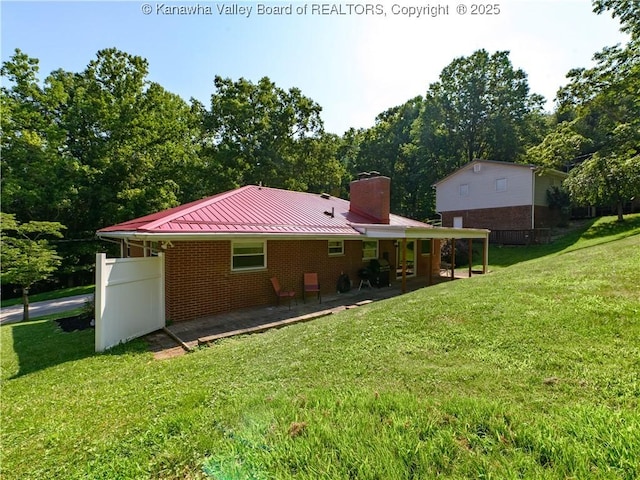 806 Whispering Way S, Charleston, WV 25303 - back of property featuring a standing seam roof, a chimney, a yard, a patio area, and brick siding