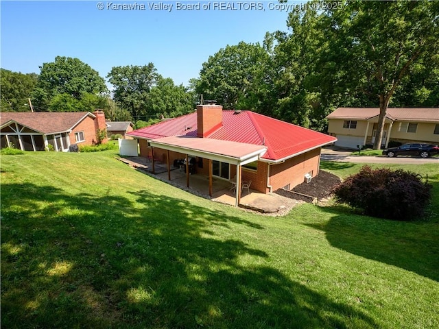 806 Whispering Way S, Charleston, WV 25303 - back of house featuring a lawn, a chimney, a metal roof, a patio area, and brick siding