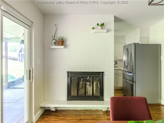 806 Whispering Way S, Charleston, WV 25303 - detailed view of stainless steel fridge, wood finished floors, and a brick fireplace