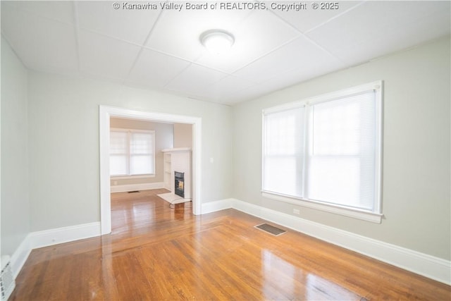 512 Maxwell St, Charleston, WV 25311 - spare room featuring wood finished floors, a fireplace with flush hearth, a paneled ceiling, and healthy amount of natural light
