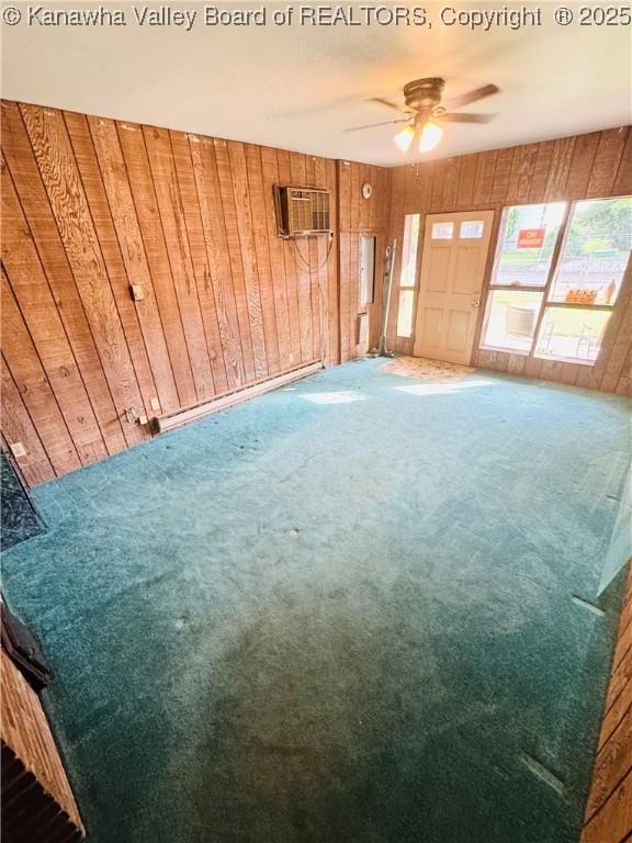 8612 Maryland Ave, Marmet, WV 25315 - unfurnished living room featuring carpet floors, wooden walls, a ceiling fan, and a wall mounted air conditioner