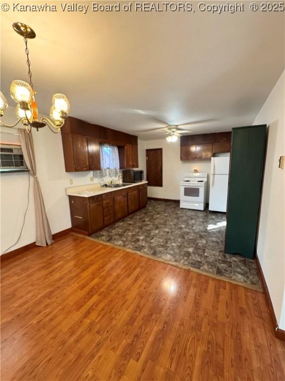 8612 Maryland Ave, Marmet, WV 25315 - kitchen featuring freestanding refrigerator, stove, a chandelier, dark wood-style flooring, and ceiling fan