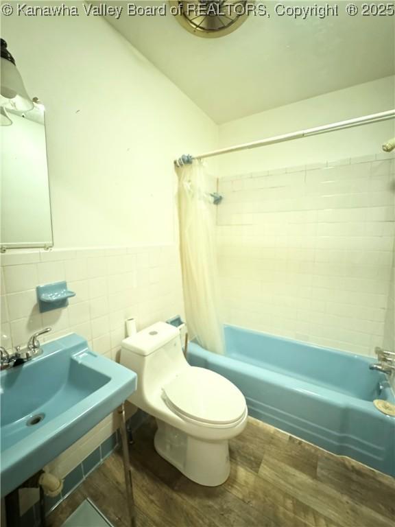 8612 Maryland Ave, Marmet, WV 25315 - full bathroom featuring wood finished floors, shower / tub combo, tile walls, and a wainscoted wall