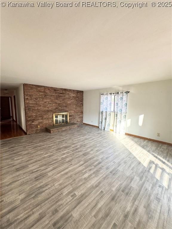8612 Maryland Ave, Marmet, WV 25315 - unfurnished living room featuring wood finished floors and a large fireplace