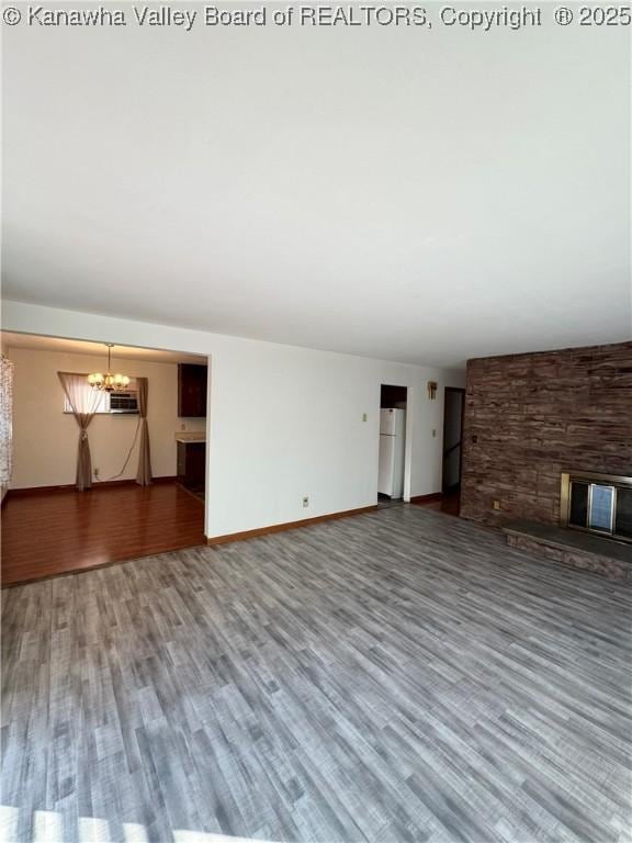 8612 Maryland Ave, Marmet, WV 25315 - unfurnished living room featuring a chandelier, wood finished floors, and a fireplace