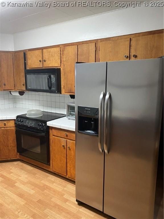 510 S Railway St, Cedar Grove, WV 25039 - kitchen featuring black appliances, brown cabinetry, and tile countertops