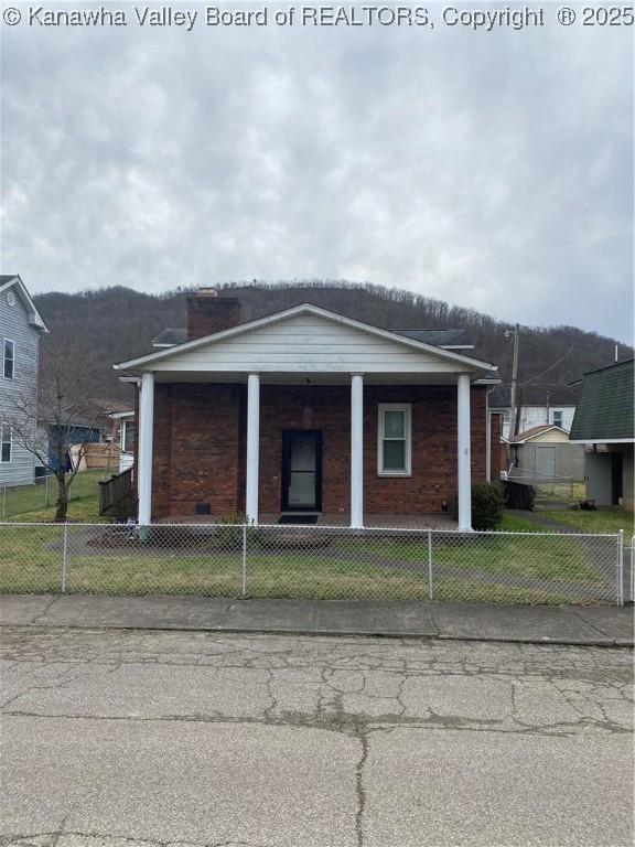 510 S Railway St, Cedar Grove, WV 25039 - view of front of property with a porch, a fenced front yard, brick siding, and a chimney